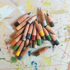 many different colored crayons are on the ground