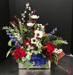 an arrangement of red, white and blue flowers