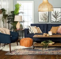 a living room with blue couches and pillows on the floor next to a coffee table