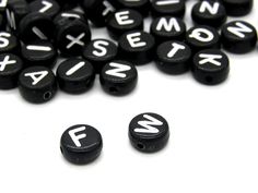 several black and white typewriter beads on a white surface with the letters spelled out