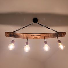 a wooden light fixture with five bulbs hanging from it's center and the name lathrome on top