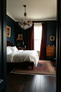 a bed sitting in a bedroom next to a chandelier above a wooden floor