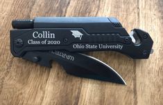 a knife that is sitting on top of a wooden table with the name collin class of 2020 written on it