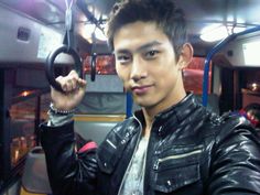 a young man is holding his hand up to the camera while riding on a bus