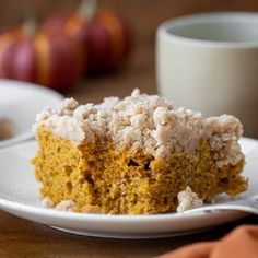 a piece of cake sitting on top of a white plate next to a cup and saucer