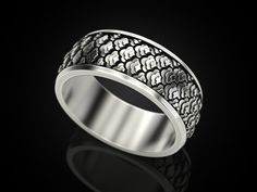 a silver ring with black and white designs on the inside, in front of a black background