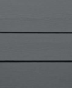 the side of a gray wooden building with white siding