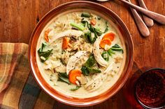 a bowl of chicken and vegetable soup on a wooden table