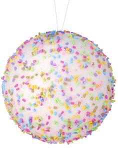 a round cake with sprinkles on it is hanging from a string and decorated with colored confetti