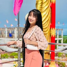 a woman standing next to a pink umbrella