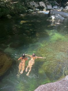 two people are swimming in the river together