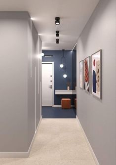 an empty hallway with blue walls and pictures on the wall