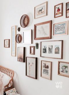 a wall with many framed pictures on it