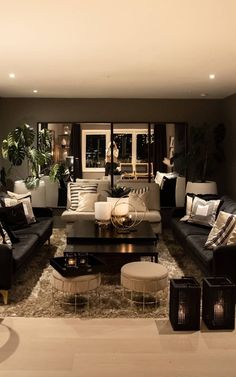 a living room filled with lots of furniture and pillows on top of a carpeted floor