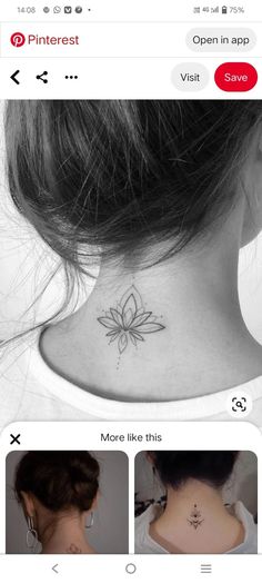 the back of a woman's neck has a small flower tattoo on it