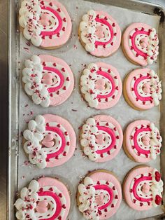 pink and white decorated cookies on a baking sheet