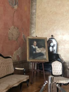 a living room with an old fashioned couch and painting on the wall next to it