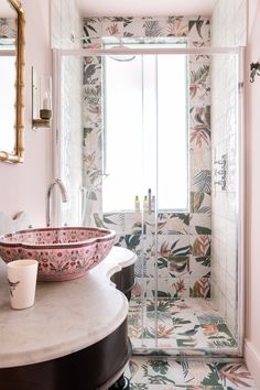 a bathroom with pink walls and floral wallpaper