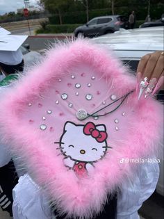 a hello kitty fan is being held by a girl in a white dress and pink fur