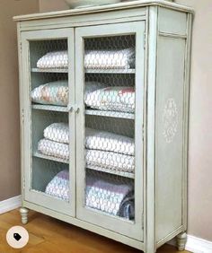 a white cabinet with many folded towels in it