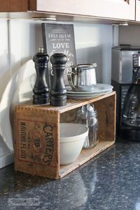 an old crate is used as a shelf for cooking utensils and other kitchen accessories