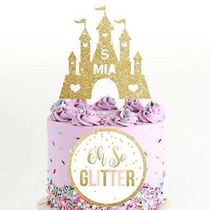 a cake with pink frosting and gold glitter on top, in front of a white background