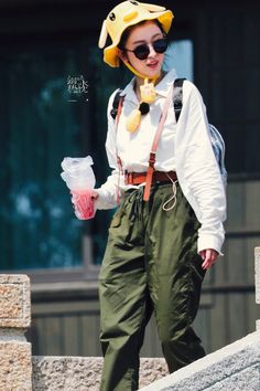 a woman wearing green pants and a yellow hat