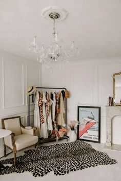 a white room with a chandelier and some clothes