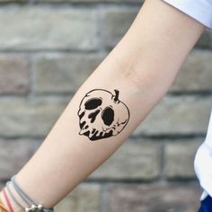 a person with a skull tattoo on their arm