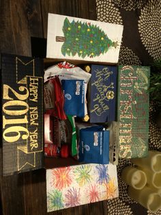 some candy bars are in a box on a table next to pine cones and candles