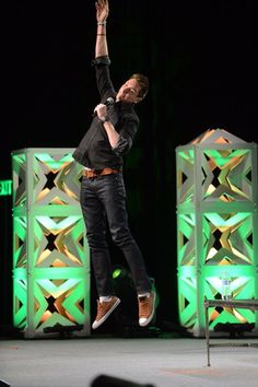 a man jumping in the air on top of a stage