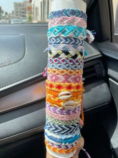 a stack of bracelets sitting on top of a car dashboard next to a steering wheel