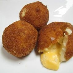 three fried food items on a plate with cheese and sauce in the middle, ready to be eaten