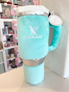 a blue cup with a white cap on it sitting on top of a counter next to a shelf