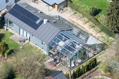 an aerial view of a house with solar panels on it's roof and windows