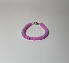 A beaded bracelet made with clay beads that contain pink, and purple in a random assortment. Finished off with a lobster clip to easily clip on and off. Clay Beaded Bracelet, Saint Louis, Pink And Purple, Clay Beads, Clip On, Bracelet Making, Beaded Bracelet, Pink Purple, Jewelry Bracelets