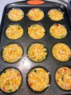 the muffin tins are filled with different types of food and cheese on top