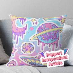 a pillow with the words support independent artists on it, and an image of saturn