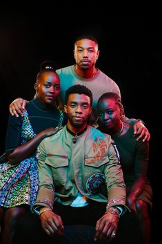 a group of people sitting next to each other in front of a black background,