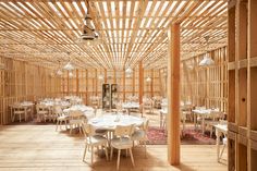 the inside of a restaurant with wooden walls and tables set up for an outdoor meal