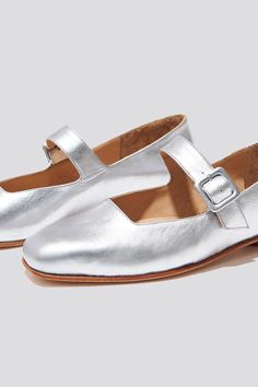 The Eugenia Flat is a modern interpretation of the classic mary jane flat featuring a square toe, angular topline and oval-shaped heel. This pair is crafted from metallic silver kidskin leather and a matching buckle. Who it’s for: The woman who is looking for mood-enhancing emotional pieces that defy reason, yet work perfectly with her style and sense of expression. Kidskin upper and undyed vegetable-tanned leather lining. Leather sole with stacked leather heel measuring 18mm. Handmade in Argent Silver Closed Toe Leather Flats, Silver Closed Toe Flats With Leather Sole, Square Toe Mary Jane, Womens Mary Janes, Mary Jane Flats, Etsy Fashion, Vegetable Tanned Leather, Beautiful Shoes, High Quality Leather