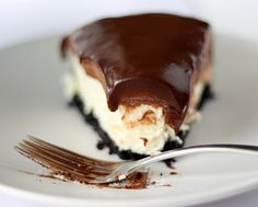 a piece of chocolate and cream cheesecake on a white plate with a silver fork