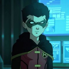 an animated image of a man in a red and black costume with green eyes, standing in front of a computer screen