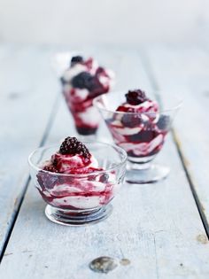 three small bowls filled with ice cream and berries