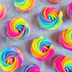 cupcakes with rainbow frosting on a baking sheet