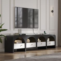 an entertainment center with two white drawers and a flat screen tv mounted on the wall