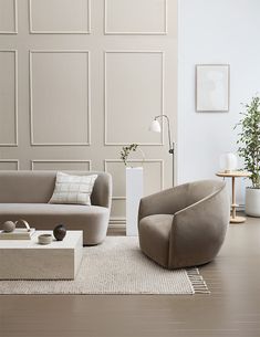 a living room with two couches, a coffee table and a plant in the corner