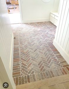 an open door leading into a room with brick flooring