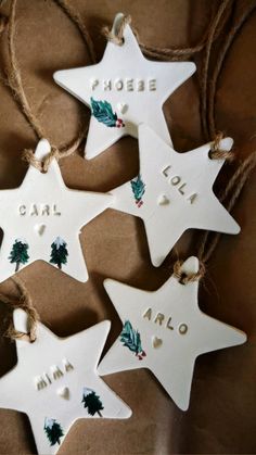 three white ceramic christmas ornaments hanging from twine