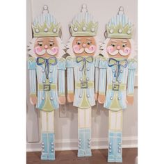 three wooden nutcrackers are standing next to each other in front of a wall